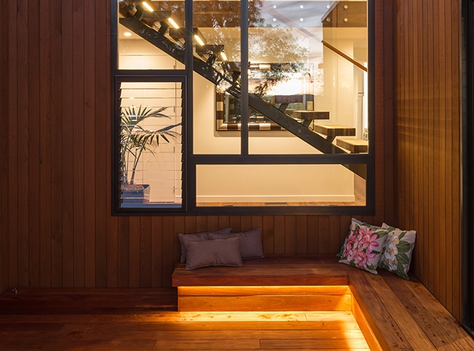 Warm timber interior with dramatic staircase