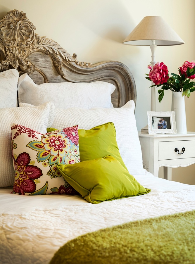 Elegant bedroom with ornate headboard and fresh flowers